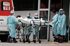 Nhân viên y tế chuyển bệnh nhân COVID-19 tới bệnh viện ở Brasilia, Brazil, ngày 11/3/2021. (Ảnh: THX/TTXVN)