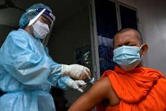 Nhân viên y tế tiêm vaccine ngừa COVID-19 cho nhà sư tại Phnom Penh, Campuchia. Trẻ em dưới 5 tuổi chưa được tiêm vaccine. (Ảnh: AFP/TTXVN)