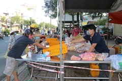 Cần Thơ mở thêm nhiều điểm bán thực phẩm ngoài đường phố giúp người dân thuận tiện mua sắm. Người mua và người bán giữ khoảng cách, không tiếp xúc trực tiếp để phòng, chống dịch. (Ảnh: Ngọc Thiện/TTXVN)