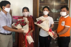 Tổng lãnh sự Việt Nam tại Preah Sihanouk Vũ Ngọc Lý (trái) và đại diện công ty OpenNet chúc mừng hai cô giáo Nguyễn Thị Sương (áo đỏ) và Trần Thị Hoài An. (Ảnh: Trần Long/TTXVN)