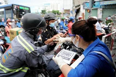 Người dân khai báo y tế để vào Quận Gò Vấp trong những ngày đầu thực hiện giãn cách xã hội. (Ảnh: An Hiếu/ TTXVN)