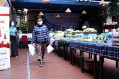 Người dân nghèo TP Hồ Chí Minh nhận nhu yếu phẩm, lương thực khi đến với Siêu thị 0 đồng. (Ảnh: Xuân Khu/TTXVN)