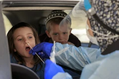 Nhân viên y tế lấy mẫu xét nghiệm COVID-19 cho một em nhỏ tại Jerusalem ngày 29/7/2021. (Ảnh: AFP/TTXVN)