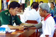Người “thầy thuốc quân hàm xanh” Lê Văn Quốc khám bệnh cho bà con Khmer nghèo khu vực biên giới biển xã Vĩnh Hải, thị xã Vĩnh Châu, tỉnh Sóc Trăng. (Ảnh: Trung Hiếu-Văn Long/TTXVN)