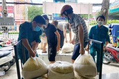 Cấp phát gạo cho người dân gặp khó khăn do ảnh hưởng dịch COVID-19. (Ảnh: Thu Hiền/TTXVN)