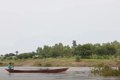 Một người đàn ông băng qua sông Oti trên một chiếc canô. (Nguồn: africa.cgtn.com)