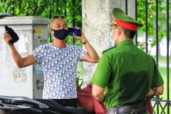 Công an phường Lê Đại Hành, Hà Nội xử lý nghiêm trường hợp ra đường không có việc thiết yếu sau nhiều lần đã nhắc nhở. (Ảnh: Thành Đạt/TTXVN)