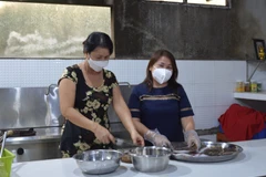 Chị Lê Thị Thanh Hương (phải) tổ chức nấu và cung cấp miễn phí hơn 90.000 suất ăn cho lực lượng tham gia chống dịch, người trong khu phong tỏa, cách ly. (Ảnh: Nhựt An/TTXVN)