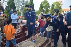 Chính quyền, đồng đội và gia đình đưa hài cốt Đại úy Phạm Văn Huy vào Nghĩa trang Liệt sỹ của xã Tiên Thanh. (Ảnh: TTXVN)