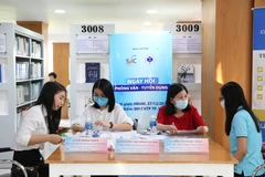 Các sinh viên lắng nghe tư vấn từ đại diện doanh nghiệp về yêu cầu và quy trình tuyển dụng. Ảnh chụp tháng 12/2020. (Nguồn: TTXVN)