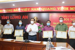 Ông Nguyễn Văn Được, Ủy viên Trung ương Đảng, Bí thư Tỉnh ủy trao Bằng khen cho các cá nhân đã có thành tích tốt trong công tác bầu cử. (Ảnh: Đức Hạnh/TTXVN)