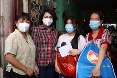 Chủ tịch Ủy ban MTTQ Thành phố Hồ Chí Minh Tô Thị Bích Châu thăm hỏi và tặng quà cho các em mồ côi vì COVID-19 tại Quận 4. (Ảnh: Thu Hương/TTXVN)