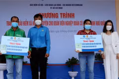  Lãnh đạo Liên đoàn Lao động quận Tân Phú, TP Hồ Chí Minh trao sổ bảo hiểm cho đoàn viên nghiệp đoàn có hoàn cảnh khó khăn. (Ảnh: Thanh Vũ/TTXVN)