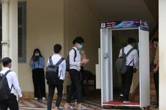 Học sinh trường Trung học Preah Yukunthor, Phnom Penh thực khử khuẩn trước khi lên lớp học. (Ảnh: Vũ Hùng/TTXVN)