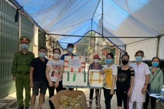 Nhóm Thiện Từ Tâm ở thị trấn Yên Viên, huyện Gia Lâm (Hà Nội) trao quà ủng hộ bà con Tổ dân phố cơ khí Yên Viên bị phong tỏa do dịch COVID-19. (Ảnh: TTXVN phát)