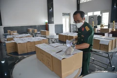 Các cán bộ Bộ Tư lệnh TP Hồ Chí Minh kiểm tra tro cốt người mắc bệnh COVID-19 tử vong tại Nhà tang lễ Thành phố Hồ Chí Minh trước khi giao về nhà cho thân nhân. (Ảnh: Mạnh Linh/TTXVN)