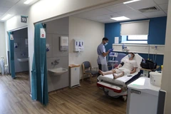 Nhân viên y tế điều trị cho bệnh nhân COVID-19 tại bệnh viện ở London, Anh. (Ảnh: AFP/TTXVN)