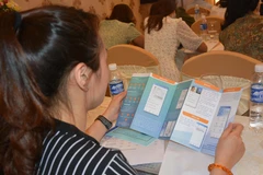 Người dân xem hướng dẫn cài đặt ứng dụng Bảo hiểm xã hội số (VssID). (Ảnh: Văn Dũng/TTXVN)