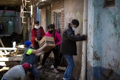 Tình nguyện viên phân phát lương thực cứu trợ do dịch COVID-19 cho người dân tại Buenos Aires, Argentina, ngày 25/7/2020. (Ảnh: AFP/TTXVN)