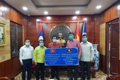 Đại diện chính quyền tỉnh Luang Namtha, Lào trao tặng tiền hỗ trợ 4 tỉnh của Việt Nam phòng chống dịch bệnh covid-19. (Ảnh: TTXVN phát)