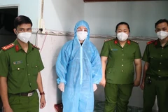 Lực lượng công an bắt tạm giam Nguyễn Thị Thu Thảo (người mặc đồ bảo hộ). (Nguồn: thanhnien.vn)