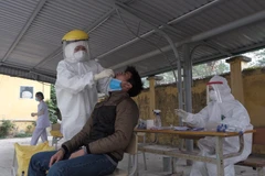 Nhân viên y tế lấy mẫu xét nghiệm COVID-19 với người có tiếp xúc gần với ca F0 tại Hà Nội. (Ảnh: Phạm Hùng - TTXVN phát)