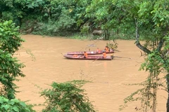 Lực lượng chức năng tìm kiếm nạn nhân. (Ảnh: TTXVN phát)