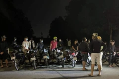 Hơn 20 thanh niên bị bắt giữ do đua xe tại Bình Dương đêm 5/6, nhiều người không đeo khẩu trang. (Ảnh: TTXVN phát)