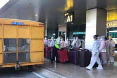Công dân Việt Nam từ nước ngoài trở về chuẩn bị rời sân bay Cam Ranh đến khu cách ly tập trung. (Ảnh: Phan Sáu/TTXVN)