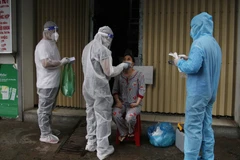 Nhân viên y tế lấy mẫu xét nghiệm test COVID-19 tại Cà Mau trong ngày 25/8. (Ảnh: Kim Há/TTXVN)