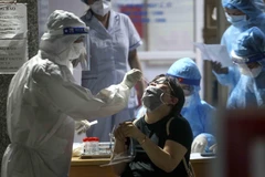 Nhân viên y tế lấy mẫu xét nghiệm COVID-19 cho những người có nguy cơ mắc COVID-19 tại Bệnh viện Phổi Hà Nội. (Ảnh: Tuấn Đức/TTXVN)