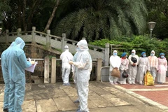 Lực lượng chức năng làm thủ tục tiếp nhận và bàn giao công dân. (Ảnh: Minh Tâm/TTXVN)