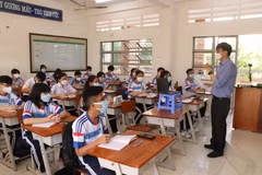 Giáo viên trên lớp mở laptop để học sinh F0, F1 đang cách ly tại nhà có thể cùng học với các bạn ở lớp. (Ảnh: Đức Hạnh/TTXVN)