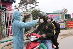 Kiểm tra thân nhiệt phòng dịch COVID-19. (Ảnh: Thanh Thương/TTXVN)