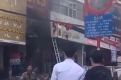 Khoảnh khắc giải cứu 2 cháu bé khỏi đám cháy. (Hình ảnh cắt từ clip)