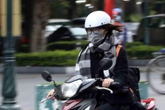 Giữ ấm cơ thể với nhiều lớp áo, khăn quàng và đeo khẩu trang khi ra đường khi trời rét đậm, rét hại. (Ảnh: Tuấn Đức/TTXVN)