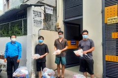 Đại diện Liên đoàn Lao động Thành phố Hồ Chí Minh trao quà cho công nhân lao động gặp khó khăn đang ở trọ tại phường Bình Thọ, thành phố Thủ Đức. (Ảnh: Thanh Vũ/TTXVN)