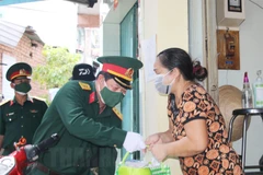 Cán bộ, chiến sỹ Trung đoàn Gia Định và các nhà hảo tâm trao quà cho người dân khó khăn quận 8. (Nguồn: hcmcpv.org.vn)