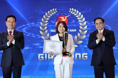 Thủ tướng Phạm Minh Chính và Bộ trưởng Bộ Thông tin và Truyền thông Nguyễn Mạnh Hùng trao giải Vàng cho các doanh nghiệp có Giải pháp số xuất sắc của giải thưởng Sản phẩm công nghệ số Make in Vietnam 2021. (Ảnh: Dương Giang/TTXVN)