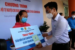  Lãnh đạo Quận ủy quận Tân Phú trao sổ bảo hiểm cho đoàn viên nghiệp đoàn có hoàn cảnh khó khăn ở quận Tân Phú. (Ảnh: Thanh Vũ/TTXVN)
