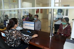 Người dân đến đăng ký mua thẻ bảo hiểm y tế tại Bảo hiểm xã hội huyện Yên Châu, tỉnh Sơn La. (Ảnh: Hữu Quyết/TTXVN)