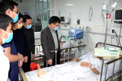 Phó Chủ tịch UBND tỉnh Nghệ An Bùi Đình Long thăm hỏi các nạn nhân bị thương trong vụ tai nạn lao động. (Ảnh: Tá Chuyên/TTXVN)