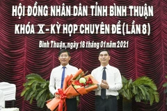 Ông Dương Văn An, Bí thư Tỉnh ủy Bình Thuận tặng hoa chúc mừng ông Lê Tuấn Phong, Chủ tịch UBND tỉnh Bình Thuận. (Ảnh: Nguyễn Thanh/TTXVN)