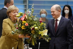 Ông Olaf Scholz tặng hoa cho Thủ tướng sắp mãn nhiệm Angela Merkel trước cuộc họp nội các ở Berlin, Đức, ngày 24/11/2021. (Ảnh: AFP/TXVN)
