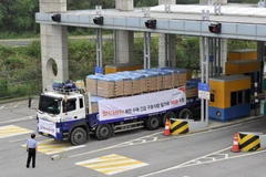 Xe tải của Hàn Quốc vận chuyển bột mì viện trợ cho Triều Tiên di chuyển qua cửa khẩu ở Paju, phía Bắc Seoul. (Ảnh: AFP/TTXVN)