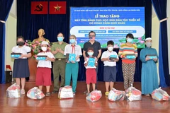 Đại diện các nhà hảo tâm trao tặng máy tính bảng và quà cho một số học sinh người Khmer và Chăm có hoàn cảnh khó khăn. (Ảnh: Xuân Khu/TTXVN)