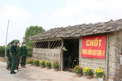 Lãnh đạo đồn biên phòng Bến Phố kiểm tra chốt phòng chống dịch trên địa bàn xã Hưng Điền A, huyện Vĩnh Hưng (Long An). Ảnh: Thanh Bình-TTXVN