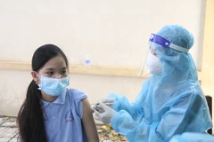 Tiêm vaccine phòng COVID-19 cho học sinh lớp 7 Trường THCS Trần Quốc Tuấn (thành phố Trà Vinh). (Ảnh: Thanh Hòa/TTXVN)