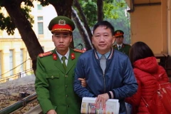 Cảnh sát dẫn giải bị cáo Trịnh Xuân Thanh vào phòng xét xử. (Ảnh: Doãn Tấn/TTXVN)