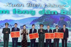 Chủ tịch Quốc hội Nguyễn Thị Kim Ngân trao tượng trưng bò giống cho đồng bào nghèo, 500 xuất quà, học bổng..cho các tỉnh. (Ảnh: Trọng Đức/TTXVN)